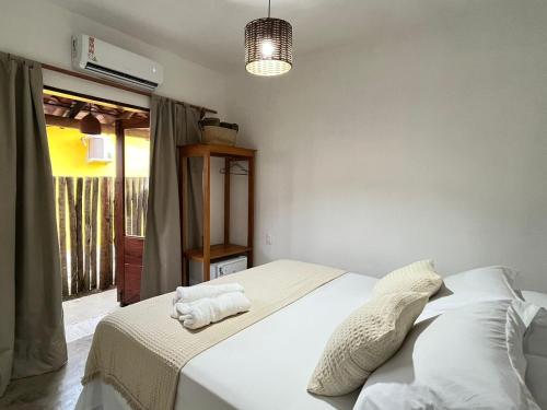 a bedroom with a bed with white sheets and pillows at Hospedaria Vale Maion in Caraíva