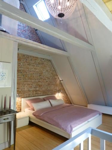 a bedroom with a bed with a brick wall at Prinzessin von Friedrichstadt in Friedrichstadt