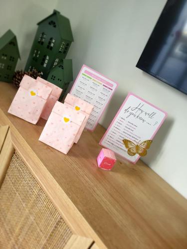 a table with two pink cards and a butterfly on it at Luxurious and Peaceful Lakeside House, Clitheroe in Clitheroe