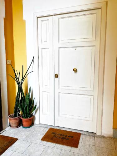 a white door in a room with two plants at Raroom Deluxe V Room in Torre del Greco