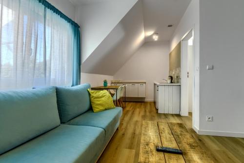 a living room with a blue couch and a table at Pajda Mazur - Ośrodek wypoczynkowy in Stare Jabłonki