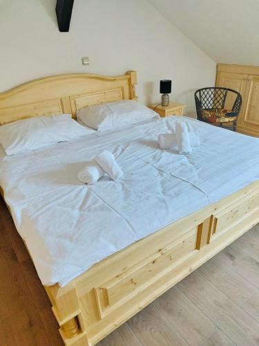 a large wooden bed with white sheets and pillows at Hotel & wellness Hejtmanka in Mladá Boleslav