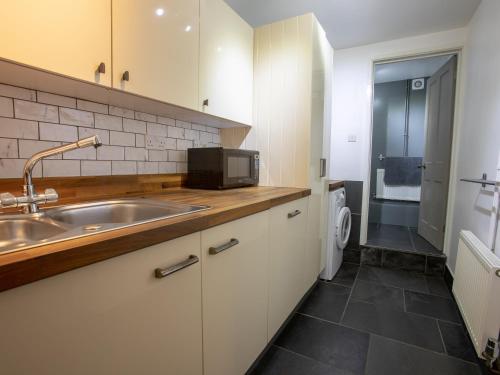 ビデフォードにあるLands Houseのシンクと電子レンジ付きのキッチン