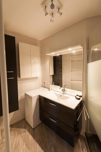 une salle de bain avec un lavabo et un miroir dans l'établissement Le Cikhara, à La Baule