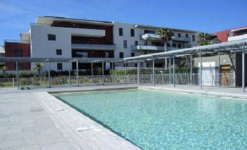 une piscine devant un immeuble dans l'établissement Le Royal Mer -Clim et Parking-, à Sète