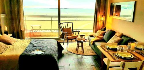Cet appartement comprend une chambre avec un lit et un salon avec une table. dans l'établissement Studio Cap sur Mer, à Boulogne-sur-Mer
