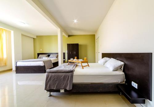 1 dormitorio con 2 camas y mesa. en Villa Santa en Chiclayo
