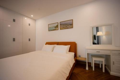 a white bedroom with a bed and a window at The Azure Villa W Large Pool And Outdoor Garden in Bùi Tiếng