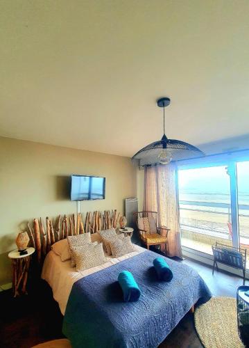 une chambre avec un grand lit avec une grande fenêtre dans l'établissement Studio Cap sur Mer, à Boulogne-sur-Mer
