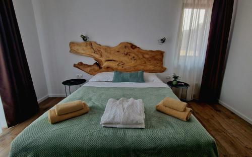 a bedroom with a large bed with two towels on it at Pensiunea Lavanda in Bratca