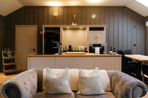 a living room with a couch in front of a kitchen at Retreat East in Ipswich