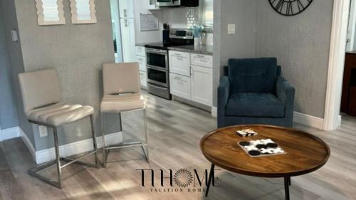 een woonkamer met twee stoelen en een tafel bij The Little Blue House Kenwood Ping Pong Hockey Family in St Petersburg