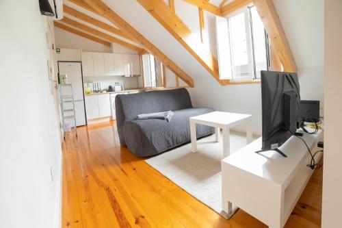 a living room with a couch and a tv at Golden Place - Cacilhas in Almada