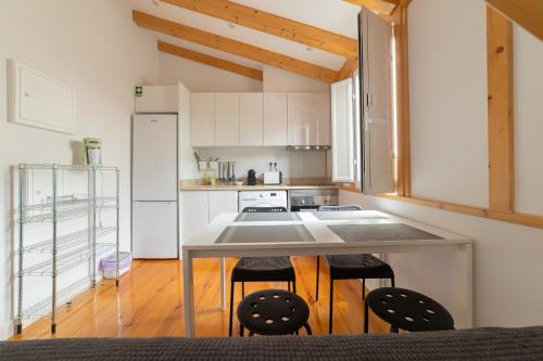 a kitchen with a table and two chairs at Golden Place - Cacilhas in Almada