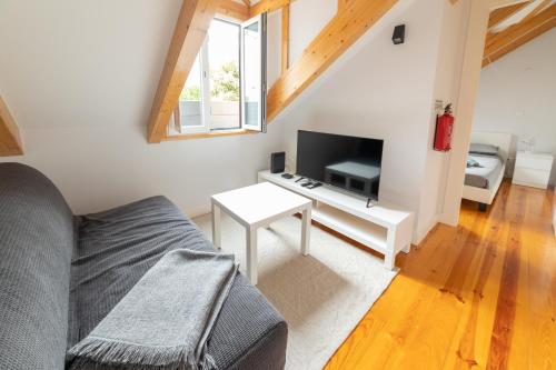 a living room with a couch and a tv at Golden Place - Cacilhas in Almada