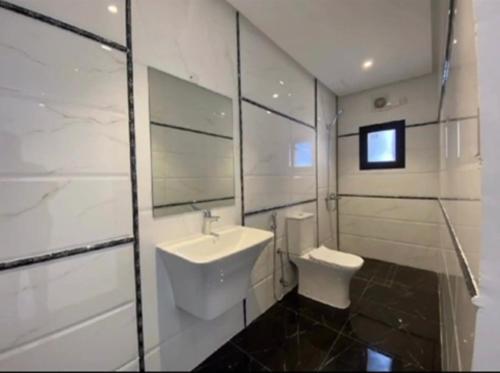 a bathroom with a sink and a toilet at شقة فخمة مودرن in Jazīrat as Sāyah