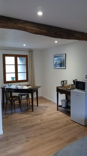 une salle à manger avec une table et une cuisine dans l'établissement Les Nuits de Vieillespeze, à Saint-Projet-de-Salers