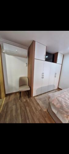 a bedroom with a bed and a chair and cabinets at Origens - Alojamento Local in Bragança