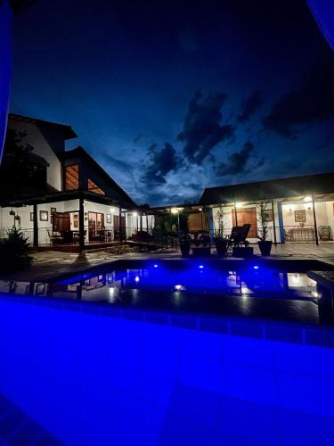 a swimming pool at night with blue lights at Casarão Coimbra Pousada Colonial in Pirenópolis