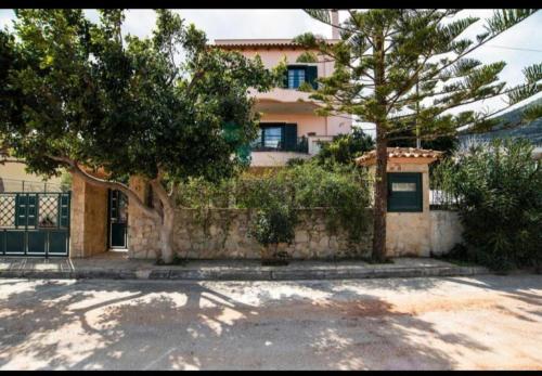 a house with trees in front of a building at Anatoli in Nea Makri in Nea Makri