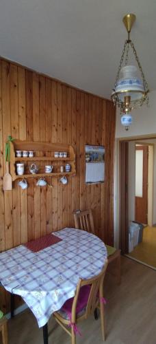 a table and chairs in a room with a wooden wall at BEST MOUNTAINs VIEW APARTMENT in Štrbské Pleso