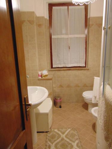 a bathroom with a sink and a toilet and a window at Podere Luma Camera Gelsomino - Lavanda in Gambassi Terme
