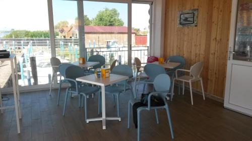 a restaurant with tables and chairs and a large window at Rifugio Punta Maestra in Pila