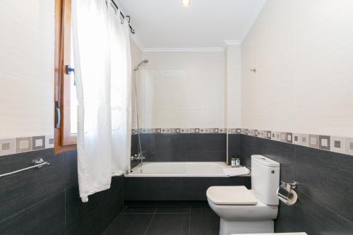 a bathroom with a toilet and a bath tub at Fantástico chalet junto al mar by CABANA Rentals in Sanxenxo