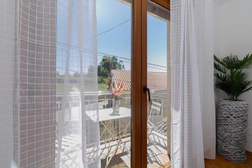 a room with a window with a view of a balcony at Fantástico chalet junto al mar by CABANA Rentals in Sanxenxo