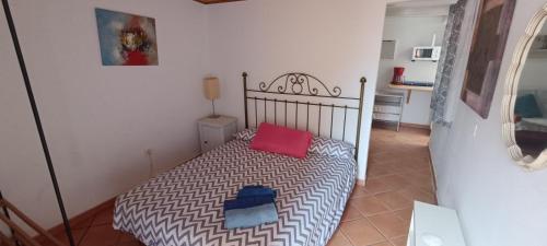 a bedroom with a bed with a red pillow on it at Apartamentos en Castillo del Romeral in Castillo del Romeral