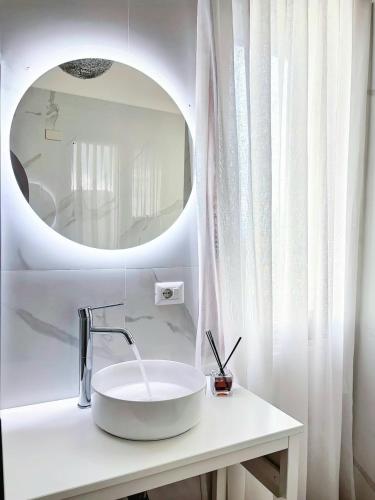 a white bathroom with a sink and a mirror at Villa del Pino, Terrazza vista Mare in Minturno