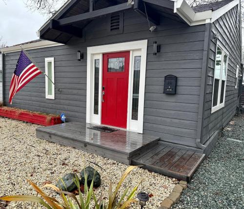 a gray house with a red door and a flag at Charming Home, near beautiful park and tennis courts! in Roseville