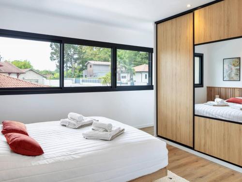 a bedroom with two beds and a large window at Villa de Luxe à Seignosse: Golf, Piscine Chauffée, Proche Plages - FR-1-791-25 in Seignosse