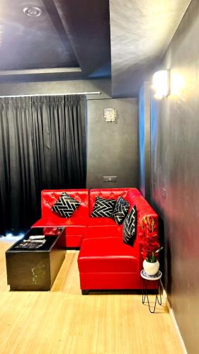 a red couch with pillows in a living room at Rizz Stay in Lucknow