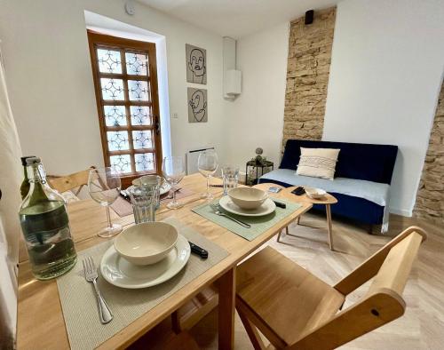 une salle à manger avec une table avec des assiettes et des verres à vin dans l'établissement La reine du faubourg, à Dijon
