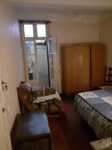 Cette chambre comprend un lit, une chaise et une fenêtre. dans l'établissement Chambre individuelle, à Béziers