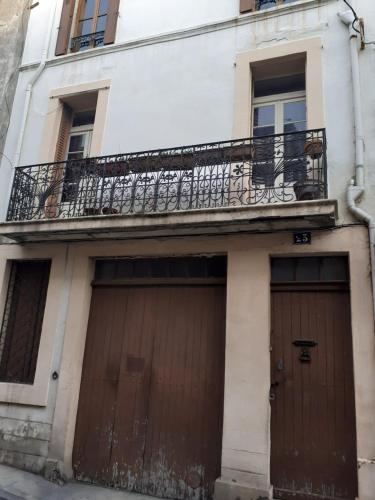 un immeuble avec deux portes de garage et un balcon dans l'établissement Chambre individuelle, à Béziers