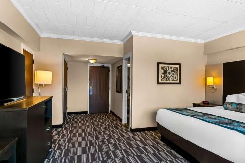 a hotel room with a bed and a television at Best Western Downtown Sudbury in Sudbury