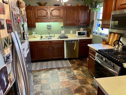 a kitchen with wooden cabinets and a stove top oven at Happy Haven w hottub, Gym, & hammocks in West AVL in Asheville