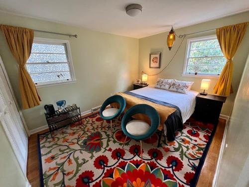 a bedroom with a bed and two chairs on a rug at Happy Haven w hottub, Gym, & hammocks in West AVL in Asheville