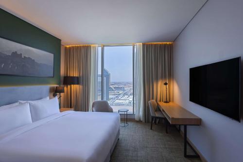 a hotel room with a bed and a desk and a television at Radisson Hotel & Residence Riyadh Olaya in Riyadh