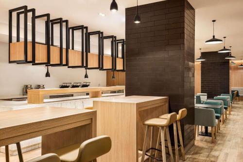 a restaurant with a bar with chairs and lights at Radisson Hotel & Residence Riyadh Olaya in Riyadh