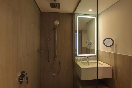 a bathroom with a shower and a sink and a mirror at Radisson Hotel & Residence Riyadh Olaya in Riyadh