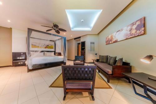 a living room with a couch and a bed at Crystals Beach Resort Belle Mare, a member of Radisson Individuals in Belle Mare