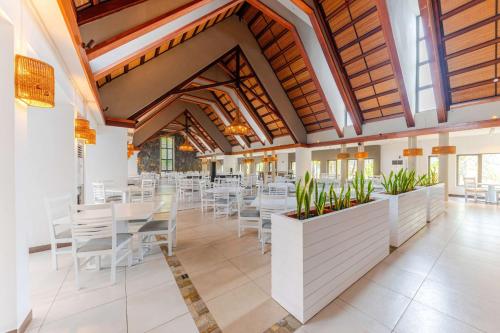 a dining room with white tables and chairs at Crystals Beach Resort Belle Mare, a member of Radisson Individuals in Belle Mare