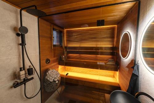 a bathroom with a shower with a glass door at Hossaville Luxe West Lake Cabin in Hossa
