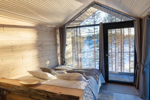a bed in a room with a large window at Hossaville Luxe West Lake Cabin in Hossa
