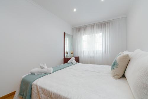a white bed in a room with a window at Puerta al encanto, descubre Tuy by CABANA Rentals in Tui