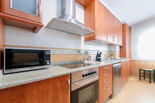 a kitchen with a microwave and a stove top oven at Puerta al encanto, descubre Tuy by CABANA Rentals in Tui