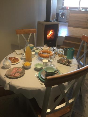 a table with food on it with a fireplace at Appartement cosy et chaleureux in La Baffe